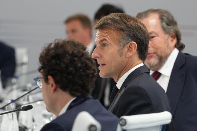 France's President Emmanuel Macron (C) reacts during a working lunch meeting of G7 members, partner countries, and artificial intelligence business leaders as part of the G7 summit, in Evian, eastern France, on June 17, 2026. A G7 summit is set to take place June 15 to 17 in the French town of Evian-les-Bains near Switzerland and it will be attended by country leaders as well as the EU's foreign policy chief and ministers from Brazil, Canada, the United Arab Emirates and Turkey. (Photo by Julia Demaree Nikhinson / POOL / AFP)