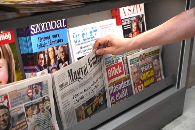 A vendor sorts media in a shelf with different daily newspapers, weeklies and magazines on display at a newsstand in a shopping mall in Budapest, Hungary, on June 17, 2026. The once popular tabloid Bors has been off the market since last week. The paper's publisher, Mediaworks, announced a reorganization of its portfolio, including the closure of some newspapers. The company is affiliated with the nationalist Fidesz, the former ruling party that was ousted from power in the April 2026 elections. Mediaworks is facing a loss of revenue after the new Tisza government led by Peter Magyar decided to no longer support Fidesz-friendly media with advertising. Before the election in April, then ruling party Fidesz is said to have directly or indirectly controlled about 80 percent of the media market in Hungary, while the press freedom of the few remaining independent media outlets was systematically obstructed by the government. (Photo by Attila KISBENEDEK / AFP)