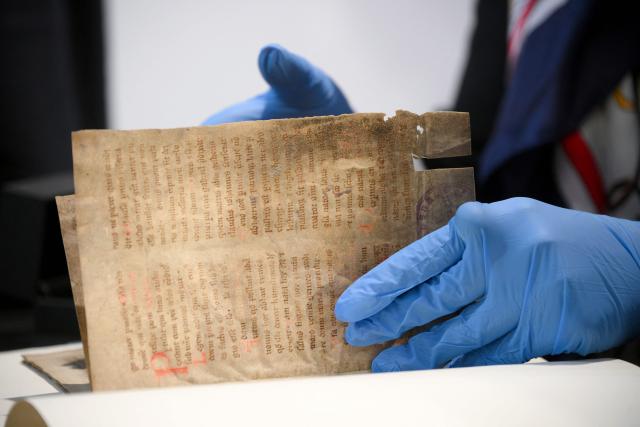 Polish Minister of Culture Marta Cienkowska looks at medieval parchment leaves containing part of the text of the Polish hymn "Gaude Mater Polonia," estimated to date from the late 14th century, as cultural artifacts looted by the German occupying forces during World War II are restituted to Poland, during the German-Polish Forum at the Foreign Ministry in Berlin on June 17, 2026. (Photo by RALF HIRSCHBERGER / AFP)