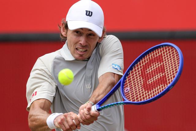 Australia's Alex de Minaur hits a return Canada's Denis Shapovalov during their men's singles round of 16 tennis match on day three of the ATP HSBC Championships at Queen's Club in west London on June 17, 2026. (Photo by Adrian DENNIS / AFP)