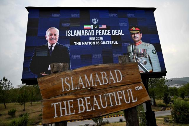An electronic board featuring Pakistan's Prime Minister Shehbaz Sharif (L) alongside Army Chief and Field Marshal Syed Asim Munir is displayed along a roadside in Islamabad on June 17, 2026, after the US–Iran peace deal announcement. Top officials from the United States and Iran will meet at a luxury mountainside resort in Switzerland on June 19, to sign a deal -- which Pakistan has helped mediate -- to bring the Middle East war to an end. (Photo by Aamir QURESHI / AFP)