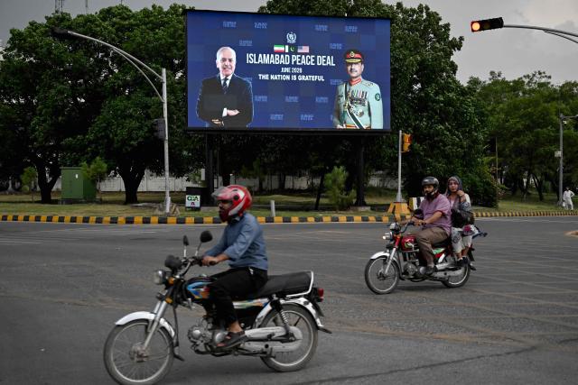 Commuters ride past an electronic board featuring Pakistan's Prime Minister Shehbaz Sharif (L) with Army Chief and Field Marshal Syed Asim Munir, displayed along a roadside in Islamabad on June 17, 2026, after the US–Iran peace deal announcement. Top officials from the United States and Iran will meet at a luxury mountainside resort in Switzerland on June 19, to sign a deal -- which Pakistan has helped mediate -- to bring the Middle East war to an end. (Photo by Aamir QURESHI / AFP)