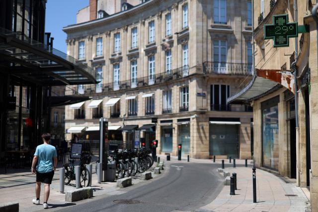 A passerby walks past a pharmacy sign displaying the temperature of 29 degrees celsius in Bordeaux, south-western France, on June 17, 2026. A heatwave will hit France on June 17, 2026 and last for several days, right in the middle of the baccalaureate exams, with temperatures that could reach up to 40°C in some areas on June 21, the first day of summer. (Photo by ROMAIN PERROCHEAU / AFP)