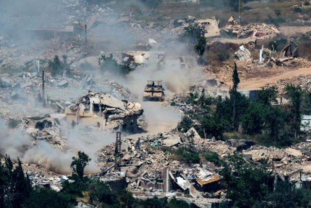 TOPSHOT - This picture taken from a position in the Upper Galilee in northern Israel, near the Israel-Lebanon border shows Israeli Merkava tanks driving along a road past destroyed buildings in southern Lebanon on June 17, 2026. Lebanon and Israel have been holding direct talks in Washington since April, seeking to end the hostilities between Israel and Hezbollah and separate their conflict from the wider regional war. (Photo by JACK GUEZ / AFP)