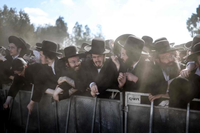 Ultra-Orthodox Jews react as they stand behind a barrier during a protest against military conscription outside Bet Lid military prison in Kfar Yona on June 17, 2026. Israeli lawmakers voted on June 10 to advance a bill that would allow most ultra-Orthodox Jewish men to avoid military conscription, despite fierce opposition protests. Ultra-orthodox men have largely been exempted from service throughout Israel's modern history, but the Supreme Court has repeatedly challenged that status in recent years culminating in a 2024 ruling that the government must conscript them. (Photo by Ilia YEFIMOVICH / AFP)