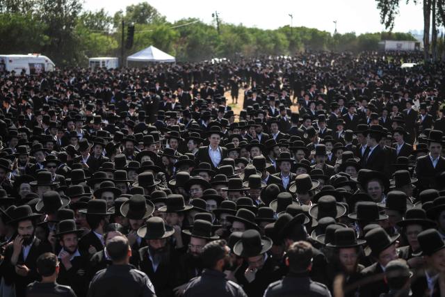Israeli security forces stand guard as ultra-Orthodox Jews gather to protest against military conscription outside Bet Lid military prison in Kfar Yona on June 17, 2026. Israeli lawmakers voted on June 10 to advance a bill that would allow most ultra-Orthodox Jewish men to avoid military conscription, despite fierce opposition protests. Ultra-orthodox men have largely been exempted from service throughout Israel's modern history, but the Supreme Court has repeatedly challenged that status in recent years culminating in a 2024 ruling that the government must conscript them. (Photo by Ilia YEFIMOVICH / AFP)