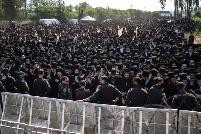 Israeli security forces stand guard as ultra-Orthodox Jews gather to protest against military conscription outside Bet Lid military prison in Kfar Yona on June 17, 2026. Israeli lawmakers voted on June 10 to advance a bill that would allow most ultra-Orthodox Jewish men to avoid military conscription, despite fierce opposition protests. Ultra-orthodox men have largely been exempted from service throughout Israel's modern history, but the Supreme Court has repeatedly challenged that status in recent years culminating in a 2024 ruling that the government must conscript them. (Photo by Ilia YEFIMOVICH / AFP)