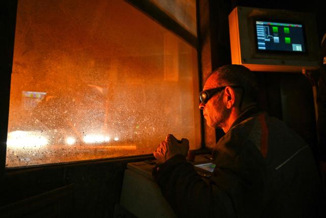 An employee observes the process of making sand moulds for the production of tracks at KNDS Deutschland Tracks GmbH during a visit as part of the Cleantech Future Festival in Remscheid, western germany on June 17, 2026. KNDS Deutschland Tracks GmbH is a global leader in the development and manufacture of tracks and undercarriage components for tanks and armoured vehicles. The international Future Cleantech Festival brings together high-level UN climate policy and research with practical insights into European heavy industry (Photo by Ina FASSBENDER / AFP)