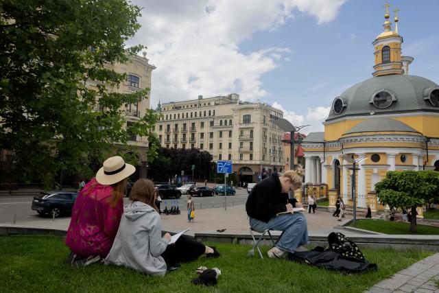 Teenagers are seen drawing in the Podil neighbourhood in Kyiv on June 17, 2026, amid the Russian invasion of Ukraine. (Photo by Tetiana DZHAFAROVA / AFP)