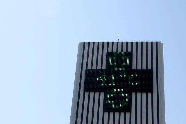 This photograph shows a pharmacy sign displaying the temperature of 41 degrees celsius in Creon near Bordeaux, south-western France, on June 17, 2026. A heatwave will hit France on June 17, 2026 and last for several days, right in the middle of the baccalaureate exams, with temperatures that could reach up to 40°C in some areas on June 21, the first day of summer. (Photo by ROMAIN PERROCHEAU / AFP)