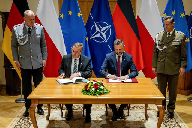 Poland's Deputy Prime Minister and Defence Minister Wladyslaw Kosiniak-Kamysz (2ndR) and Germany's Defence Minister Boris Pistorius (2ndL) sign a defence agreement between Poland and Germany at the Defence Ministry in Warsaw, Poland, on June 17, 2026. After signing defence pacts with France and UK, Warsaw signed an agreement with Germany on June 17 -- but its sweep was trimmed fearing right-wing opposition and the prospect of a presidential veto. Poland -- the only NATO member to border both Russia and Ukraine -- has sought to bolster its defence in more than four years of Moscow's invasion next door. The agreements were signed on the 35th anniversary of the 1991 Treaty of Good Neighbourship, which set up security, economic, and cultural cooperation between the two countries. (Photo by Wojtek RADWANSKI / AFP)