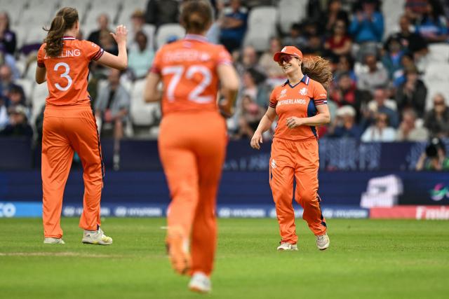 Netherlands' Myrthe van den Raad (R) celebrates with teammates after dismissing India's captain Harmanpreet Kaur (not pictured) during the ICC Women's T20 cricket world cup 2026 game between India and The Netherlands, at Headingley in Leeds, northern England on June 17, 2026. (Photo by Oli SCARFF / AFP)