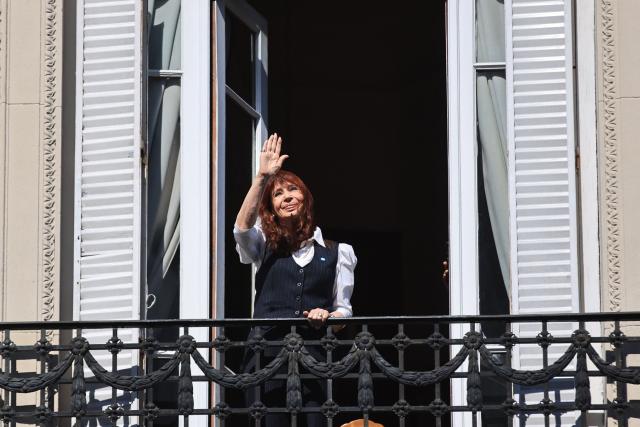 (FILES) Former Argentine president (2007–2015) Cristina Kirchner waves from the balcony of her home in Buenos Aires upon her arrival after being questioned at the Comodoro Py courthouse on March 17, 2026. Argentine courts have issued a warning to former President Cristina Kirchner (2007–2015) as she marked the first of her six years of house arrest for corruption on June 17, 2026, due to the displays of support she is receiving outside her home. The courts reminded her that they may revoke her house arrest if she breaches the conditions set out by “disturbing the peace of the neighbourhood”, after hundreds of people gathered outside her home under the slogan “Free Cristina” on June 14, 2026. (Photo by Emiliano Lasalvia / AFP)