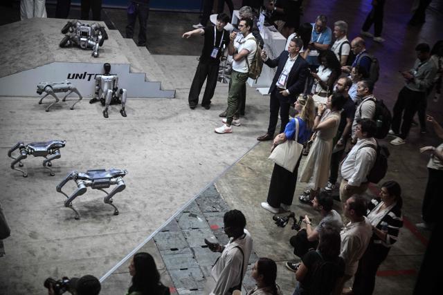 Visitors look at robots by Unitree Robotics company at the VivaTech technology startups and innovation fair at the Paris Expo Porte de Versailles, in Paris on June 17, 2026. (Photo by JULIEN DE ROSA / AFP)