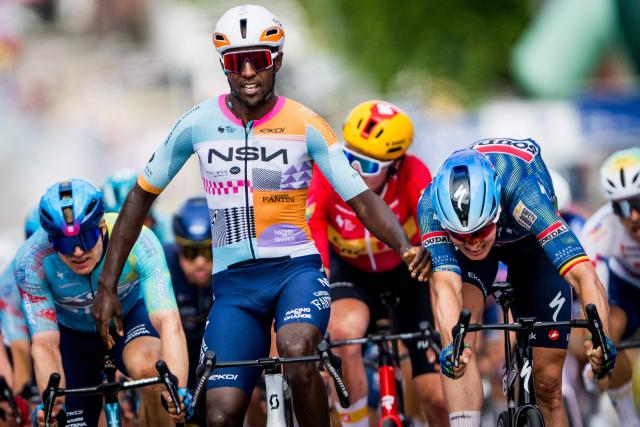 NSN Cycling Team's Eritrean rider Biniam Girmay (C) celebrates as he crosses the finish line ahead of Soudal Quick-Step's Belgian rider Tim Merlier (R) to win the 1st stage of the Tour of Belgium cycling race, 187.9 km starting and finishing in Scherpenheuvel-Zichem, on June 17, 2026. The Belgium Tour takes place from 17 to 21 June. (Photo by JASPER JACOBS / Belga / AFP) / Belgium OUT