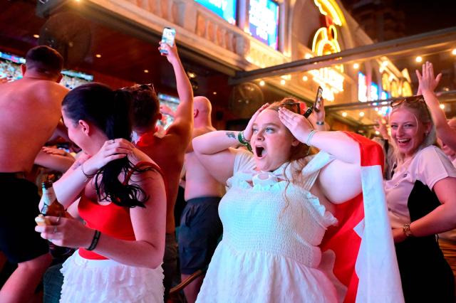 (FILES) England fans celebrate after England's first goal as they watch on a giant screen the UEFA Euro 2024 final football match between Spain and England, in Benidorm, eastern coast of Spain, on July 14, 2024. The outcome of England's World Cup opener on June 17, 2026 remains uncertain but one result appears far more predictable in Benidorm: a sharp decline in local beer stocks. The Spanish Mediterranean resort, one of Britain's favorite holiday destinations, could serve up to 80,000 litres of beer on Wednesday as England begins its World Cup campaign, according to estimates from the local hospitality industry. (Photo by JOSE JORDAN / AFP)