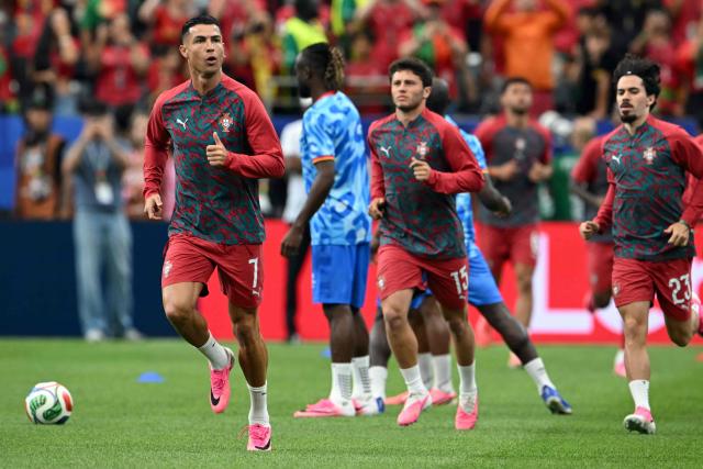 Portugal's forward #07 Cristiano Ronaldo (L), Portugal's midfielder #15 Joao Neves (C) and Portugal's midfielder #23 Vitinha warm up ahead of the 2026 World Cup Group K football match between Portugal and the Democratic Republic of Congo at the Houston Stadium in Houston on June 17, 2026.  (Photo by RONALDO SCHEMIDT / AFP)