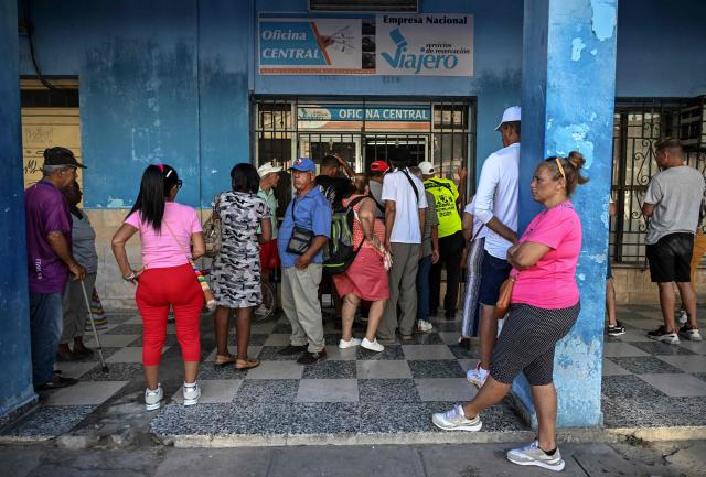 People queue outside a ticket office to buy state train and bus tickets to the country’s eastern provinces in Havana on June 17, 2026. New restrictions on interprovincial transport in Cuba come into force on June 18, 2026, with trains running every 16 days, few weekly coaches and a state system for allocating tickets according to criteria of "urgency", amid a severe fuel shortage, under pressure from Washington. (Photo by YAMIL LAGE / AFP)