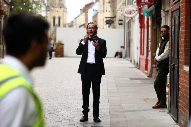 British actor-turned-politician/activist Laurence Fox gestures with his phone, live-streaming, as he stands behind  security barriers after arriving to attend a speech by British far-right activist Tommy Robinson, real name Stephen Yaxley-Lennon, to The Oxford Union, in Oxford, western England, on June 17, 2026. (Photo by Henry NICHOLLS / AFP)
