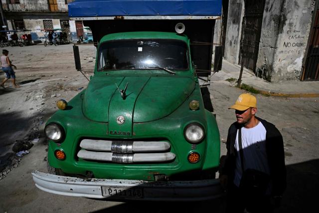 A man walks near a private lorry transporting passengers to the country's eastern provinces in Havana on June 16, 2026. New restrictions on interprovincial transport in Cuba come into force on June 18, 2026, with trains running every 16 days, few weekly coaches and a state system for allocating tickets according to criteria of "urgency", amid a severe fuel shortage, under pressure from Washington. (Photo by YAMIL LAGE / AFP)