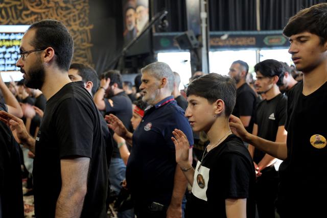 People react as Hezbollah Secretary-General Sheikh Naim Qassem addresses crowds via a giant screen during the first day of Ashura commemorations at the mausoleum of former Hezbollah leader Hassan Nasrallah in Beirut’s southern suburbs on June 17, 2026. Qassem said on June 17 that Lebanon's negotiations with Israel should be limited to "mutual security", and that the country's main demand should be restoring its sovereignty after Israeli troops invaded the south. (Photo by Anwar AMRO / AFP)