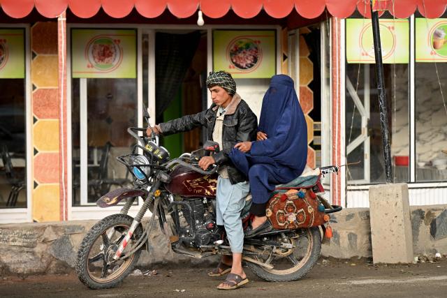 An Afghan man rides a motorcycle with a burqa-clad woman in Fayzabad district, Badakhshan province on June 17, 2026. (Photo by OMER ABRAR / AFP)