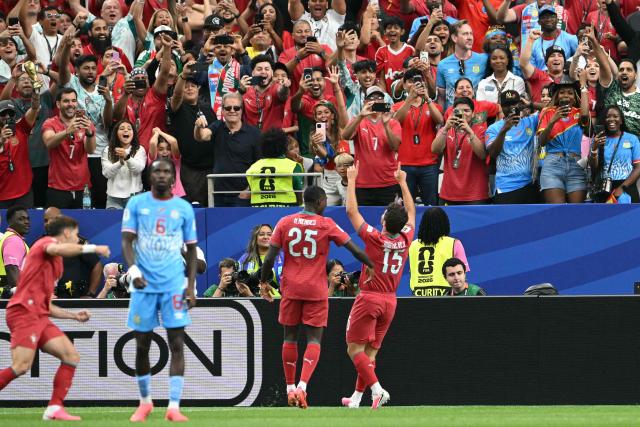 Portugal's midfielder #15 Joao Neves (R) celebrates after scoring the opening goal during the 2026 World Cup Group K football match between Portugal and the Democratic Republic of Congo at the Houston Stadium in Houston on June 17, 2026.  (Photo by RONALDO SCHEMIDT / AFP)