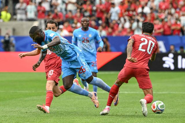 Congo DR's defender #26 Arthur Masuaku (L) fights for the ball with Portugal's defender #20 Joao Cancelo (R)  during the 2026 World Cup Group K football match between Portugal and the Democratic Republic of Congo at the Houston Stadium in Houston on June 17, 2026.  (Photo by RONALDO SCHEMIDT / AFP)