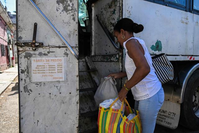 A woman boards a private lorry transporting passengers to the country’s eastern provinces in Havana on June 16, 2026. New restrictions on interprovincial transport in Cuba come into force on June 18, 2026, with trains running every 16 days, few weekly coaches and a state system for allocating tickets according to criteria of "urgency", amid a severe fuel shortage, under pressure from Washington. (Photo by YAMIL LAGE / AFP)