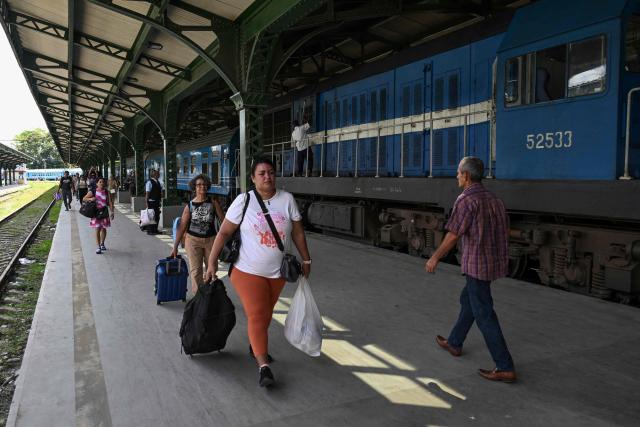 Passengers carry their luggage along a platform at the Ferrocarriles de Cuba Station in Havana on June 16, 2026. New restrictions on interprovincial transport in Cuba come into force on June 18, 2026, with trains running every 16 days, few weekly coaches and a state system for allocating tickets according to criteria of "urgency", amid a severe fuel shortage, under pressure from Washington. (Photo by YAMIL LAGE / AFP)