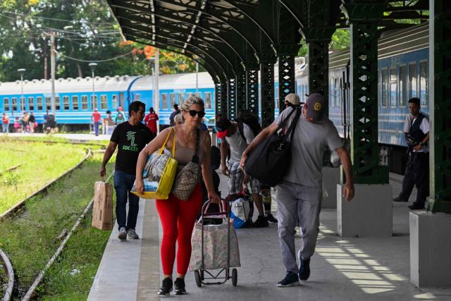 Passengers carry their luggage along a platform at the Ferrocarriles de Cuba train Station in Havana on June 16, 2026. New restrictions on interprovincial transport in Cuba come into force on June 18, 2026, with trains running every 16 days, few weekly coaches and a state system for allocating tickets according to criteria of "urgency", amid a severe fuel shortage, under pressure from Washington. (Photo by YAMIL LAGE / AFP)