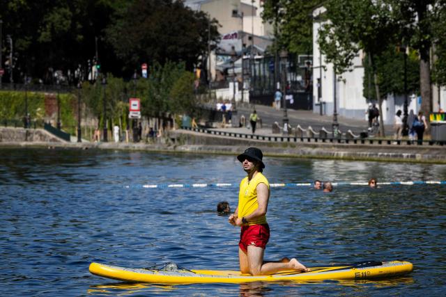 A lifeguard  watches over swimmers the Canal Saint-Martin in Paris on June 17, 2026. France braced for another heat wave on June 17, with Paris allowing swimming in one of its canals so residents could cope with the heat. (Photo by JOEL SAGET / AFP)