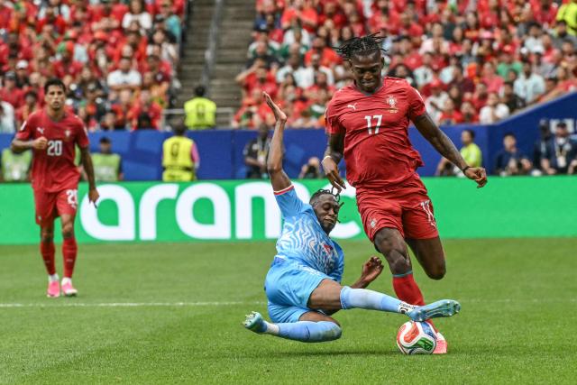 TOPSHOT - Congo DR's forward #17 Cedric Bakambu (R) fights for the ball with Congo DR's defender #02 Aaron Wan-Bissaka  during the 2026 World Cup Group K football match between Portugal and the Democratic Republic of Congo at the Houston Stadium in Houston on June 17, 2026.  (Photo by RONALDO SCHEMIDT / AFP)