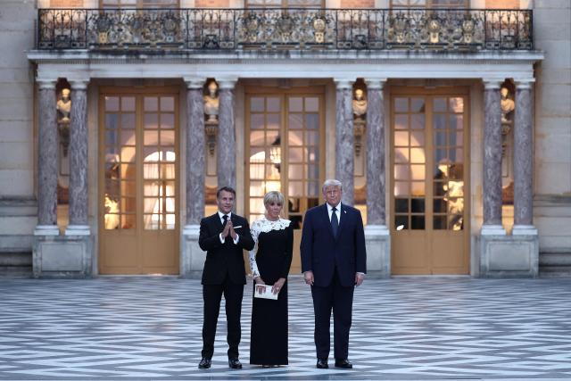 France's President Emmanuel Macron (L) and his wife Brigitte Macron (C) welcome US President Donald Trump (R) at Chateau de Versailles ahead of a dinner to celebrate the 250th anniversary of the independence of the United States, in Versailles southwest of Paris on June 17, 2026. (Photo by Guillaume BAPTISTE / AFP)