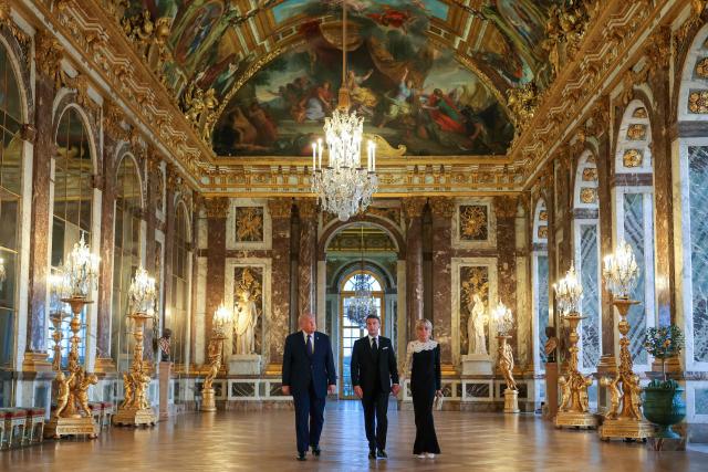 US President Donald Trump (L) receives a tour of the Chateau de Versailles from French President Emmanuel Macron and his wife Brigitte Macron ahead of a dinner on June 17, 2026 in Versailles, France. The dinner followed the conclusion of this week's Group of 7 (G7) summit in Evian, France. (Photo by Anna Moneymaker / POOL / AFP)