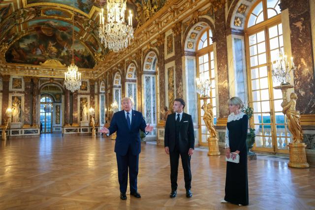 US President Donald Trump (L) receives a tour of the Chateau de Versailles from French President Emmanuel Macron and his wife Brigitte Macron ahead of a dinner on June 17, 2026 in Versailles, France. The dinner followed the conclusion of this week's Group of 7 (G7) summit in Evian, France. (Photo by Anna Moneymaker / POOL / AFP)
