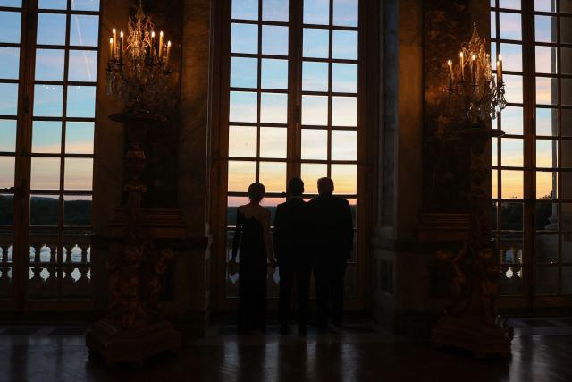 US President Donald Trump (R) receives a tour of the Chateau de Versailles from French President Emmanuel Macron and his wife Brigitte Macron ahead of a dinner on June 17, 2026 in Versailles, France. The dinner followed the conclusion of this week's Group of 7 (G7) summit in Evian, France. (Photo by Anna Moneymaker / POOL / AFP)