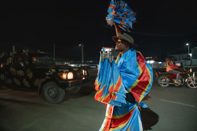 Congolese supporters dressed in the colors of the Democratic Republic of Congo's national flag celebrate the Leopards' equalizing goal in a street in Bunia at night during a FIFA World Cup match between DR Congo and Portugal in Bunia, Ituri Province, Democratic Republic of Congo, on June 17, 2026. The Congolese Leopards played their first match of the tournament in Houston, Texas (United States), against Portugal (1–1). The Democratic Republic of Congo (DRC) had last qualified for a World Cup in 1974. The country was then called Zaire, and the dictator Mobutu Sese Seko was in power (1965–1997). At nightfall in downtown Bunia, the capital of Ituri (northeast), a crowd gathered in the street, standing in front of a modest television screen. Above a barbecue where skewers sold individually were grilling, the owner of a small stall had hung up a screen so people could watch the match. (Photo by Jospin Mwisha / AFP)