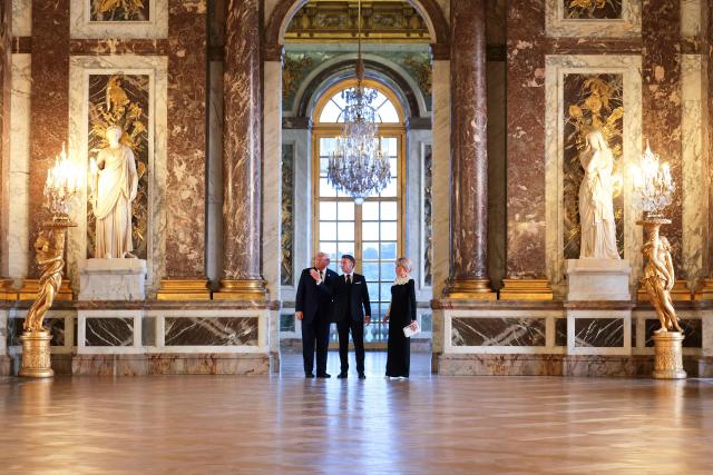 US President Donald Trump (L) receives a tour of the Chateau de Versailles from French President Emmanuel Macron and his wife Brigitte Macron ahead of a dinner on June 17, 2026 in Versailles, France. The dinner followed the conclusion of this week's Group of 7 (G7) summit in Evian, France. (Photo by Anna Moneymaker / POOL / AFP)