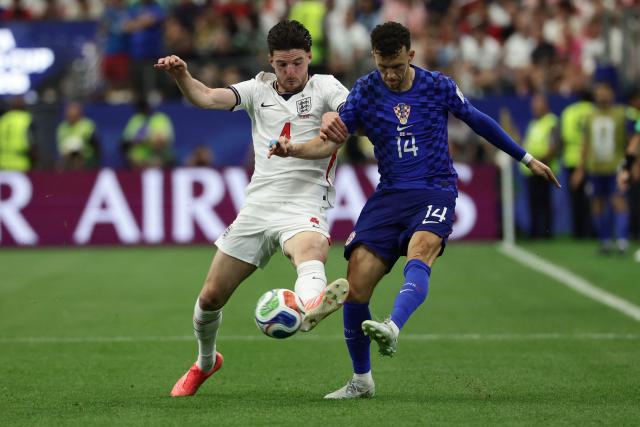 England's midfielder #04 Declan Rice (L) and Croatia's forward #14 Ivan Perisic (R) fight for the ball during the 2026 World Cup Group L football match between England and Croatia at the Dallas Stadium in Arlington on June 17, 2026.  (Photo by Aric Becker / AFP)