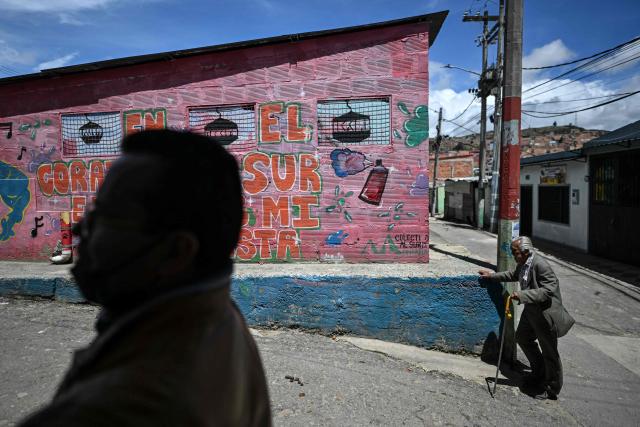 An elderly man walks in a street at Ciudad Bolivar neighbourhood, in southern Bogota, on June 17, 2026. Colombians vote on June 21, 2026 in a presidential runoff pitting a hard-right opera-singer-turned-lawyer against a leftist senator, an election with stark consequences for the country's stumbling peace process with armed groups and strained ties with Washington. (Photo by Juan BARRETO / AFP)