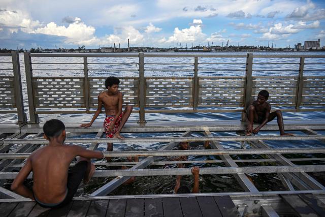 Young people bathe on a partially dismantled floating dock in Havana Bay on June 17, 2026. (Photo by YAMIL LAGE / AFP)