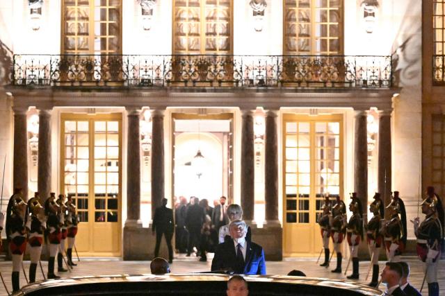 Frence's First Lady Brigitte Macron stans behind US President Donald Trump as he boards the presidential limousine following a dinner marking the 250th anniversary of US independence at the Château de Versailles in Versailles, southwest of Paris, on June 17, 2026. (Photo by Mandel NGAN / AFP)