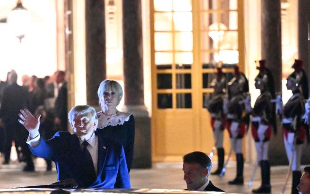 US President Donald Trump waves as he takes his leave from France's President Emmanuel Macron (R) and First Lady Brigitte Macron before boarding the presidential limousine following a dinner marking the 250th anniversary of US independence at the Château de Versailles in Versailles, southwest of Paris, on June 17, 2026. (Photo by Mandel NGAN / AFP)