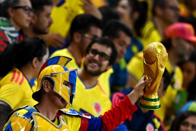 A Colombian fan holds a World Cup replica ahead of the 2026 World Cup Group K football match between Uzbekistan and Colombia at the Mexico City Stadium in Mexico City on June 17, 2026.  (Photo by CARL DE SOUZA / AFP)