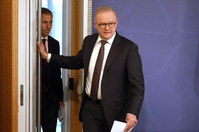 Australian Treasurer Jim Chalmers (L) walks with Australia’s Prime Minister Anthony Albanese as they arrive at a press conference regarding budget changes in Sydney on June 18, 2026. (Photo by DAVID GRAY / AFP)