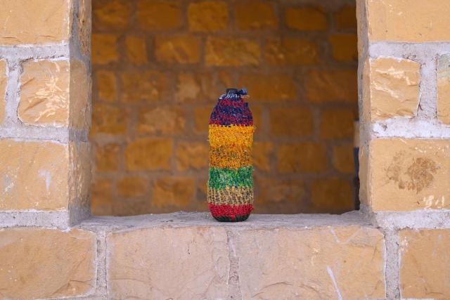 This photograph taken on May 29, 2026 shows a drinking water bottle covered in handmade jute layer to keep it cool, at herdsman Sawai Singh Bhati's house in Sanwata village on the outskirts of Rajasthan's Jaisalmer city. In India's hot plains, scorching summers have become increasingly harder to endure, requiring adaptations and forcing life into the hours of dark before the sun turns punishing. Temperatures in Singh's Sanwata village hit 45C in early June, as is often during the summer with the highest temperature recorded in the area as 49C. (Photo by Manan VATSYAYANA / AFP)
