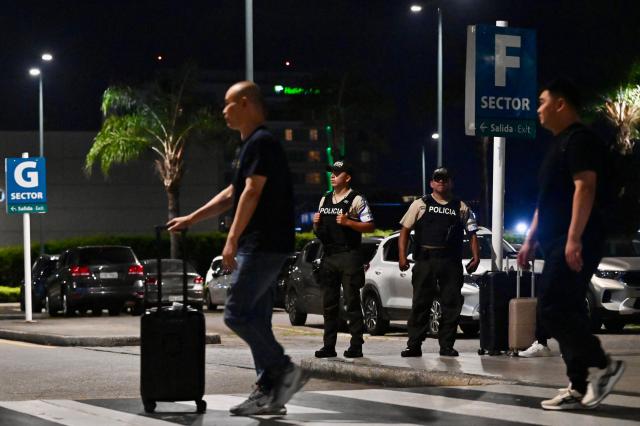 Members of the National Police guard the exterior of the international arrivals area after a criminal gang leader was shot dead at Jose Joaquin de Olmedo International Airport in Guayaquil, Ecuador, on June 17, 2026. Ecuador's Interior Minister John Reimberg identified the deceased as Carlos Suastegui, leader of the Las Aguilas gang, an armed wing of the feared criminal group Los Choneros. (Photo by MARCOS PIN / AFP)
