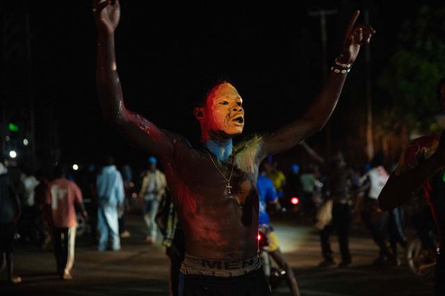 TOPSHOT - A Congolese supporter dressed in the colors of the Democratic Republic of Congo's national flag celebrates the Leopards' equalizing goal in a street in Bunia at night during a FIFA World Cup match between DR Congo and Portugal in Bunia, Ituri Province, Democratic Republic of Congo, on June 17, 2026. Ituri, a remote province in northeastern Congo, is at the epicenter of the 17th Ebola outbreak, declared on May 15 in the DRC. The virus has infected 837 people and caused 196 deaths so far, according to the latest official figures.
In the city of Bunia alone, 215 cases of infection have been confirmed, while the DRCs testing capacity is limited. The scale of the health crisis is still unknown, scientists, aid workers, and international health authorities acknowledge.
But for 90 minutes of the match, some of the roughly 100 million inhabitants say they were able to escape the worries linked to the epidemic, the conflict in the east of the country, and the violence of armed groups. (Photo by Jospin Mwisha / AFP)
