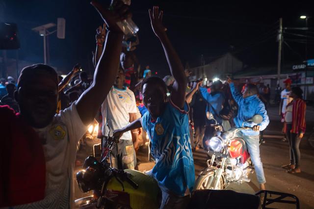 TOPSHOT - Congolese supporters celebrate the Leopards' equalizing goal in a street in Bunia at night during a FIFA World Cup match between DR Congo and Portugal in Bunia, Ituri Province, Democratic Republic of Congo, on June 17, 2026. Ituri, a remote province in northeastern Congo, is at the epicenter of the 17th Ebola outbreak, declared on May 15 in the DRC. The virus has infected 837 people and caused 196 deaths so far, according to the latest official figures.
In the city of Bunia alone, 215 cases of infection have been confirmed, while the DRCs testing capacity is limited. The scale of the health crisis is still unknown, scientists, aid workers, and international health authorities acknowledge.
But for 90 minutes of the match, some of the roughly 100 million inhabitants say they were able to escape the worries linked to the epidemic, the conflict in the east of the country, and the violence of armed groups. (Photo by Jospin Mwisha / AFP)